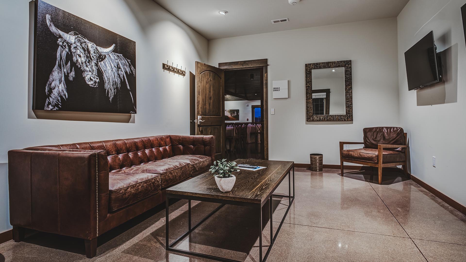 palace-events-center-trayner-iowa-bridal-party-mens-suite-leather-seating TVs and leather furniture in suite at Palace Event Center