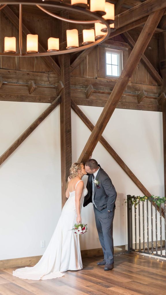 bride and groom share a kiss in loft at Palace Event Center | photo by Get Kara'd Away