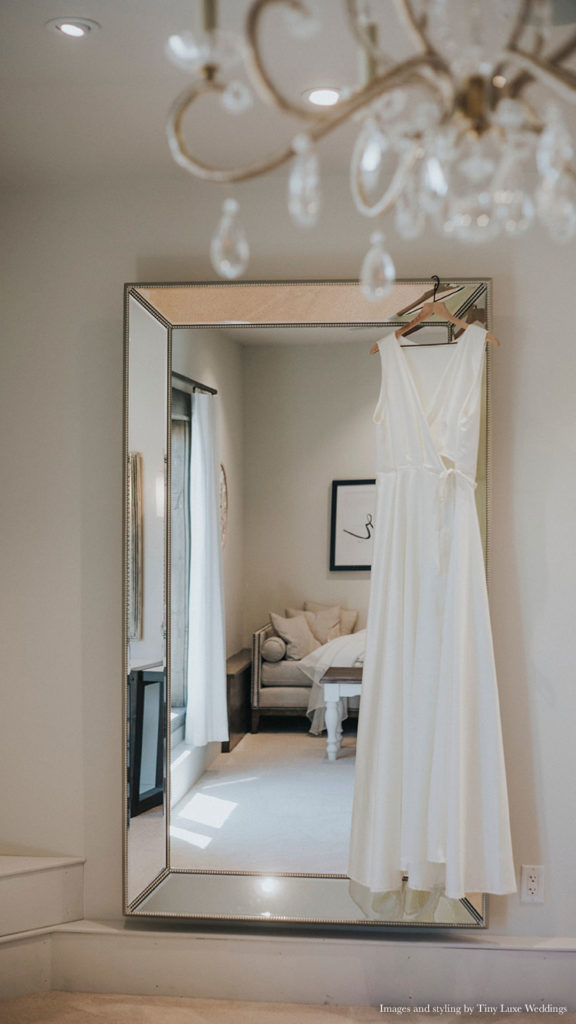 wedding dress hanging on mirror in suite at Palace Event Center | photo by Tiny Luxe Wedings