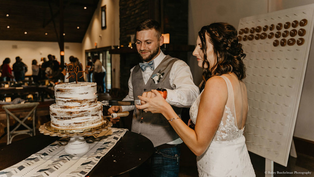Bride and groom cut cake at wedding reception at Palace Event Center