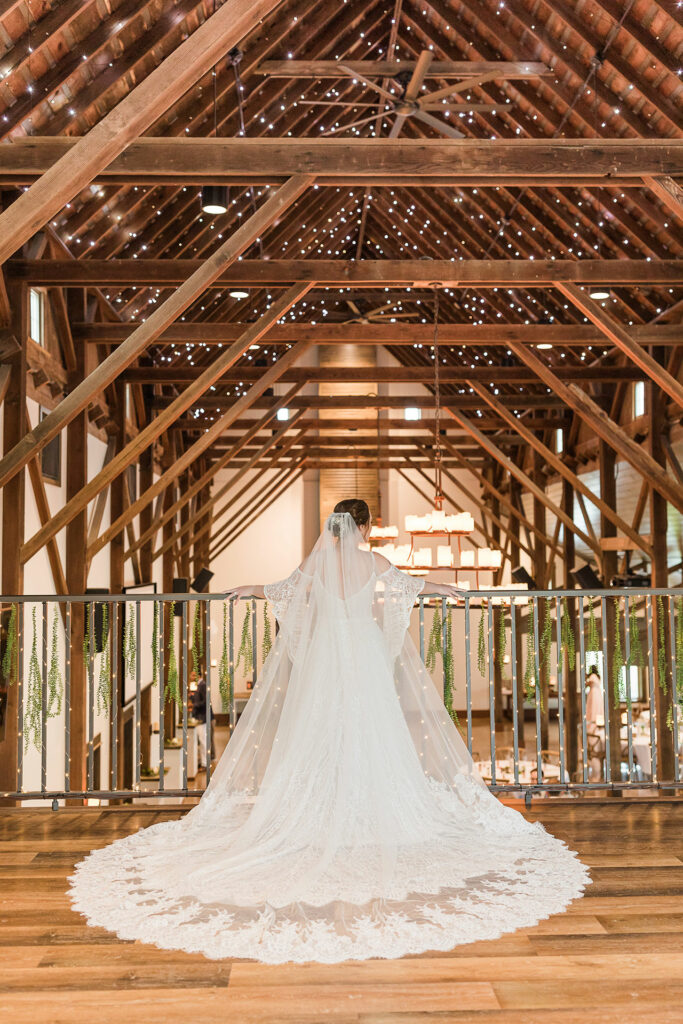 Bride showing wedding train in barn loft | Emma Christine Creative