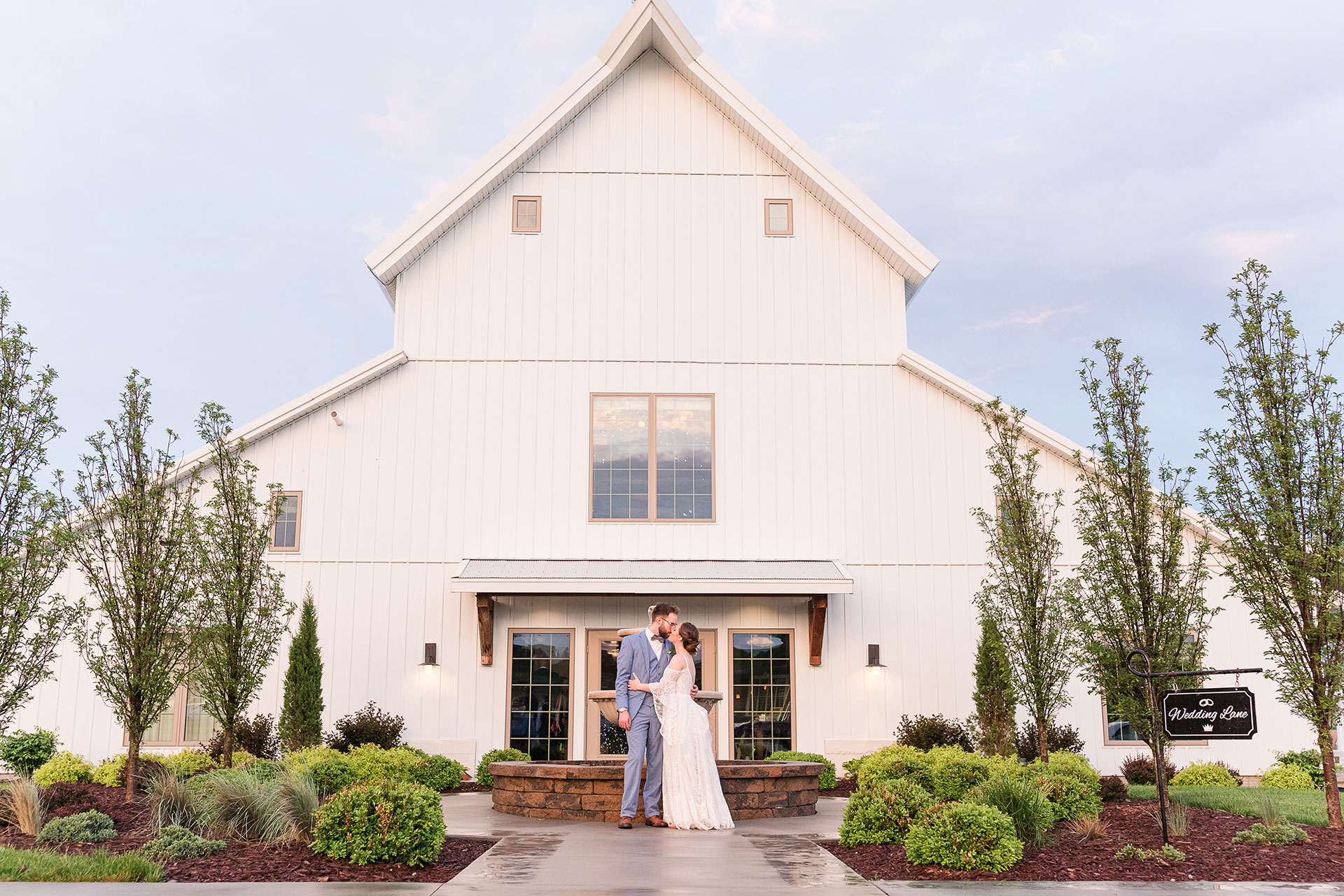 couple twirls in front of Palace Event Center barn exterior | photo by Tiny Luxe Wedings