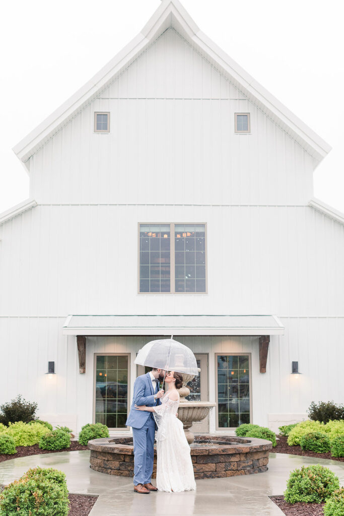 Bride and groom kiss under umbrella | Emma Christine Creative