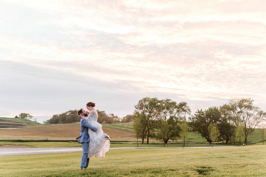 Bride and groom twirl in field | Emma Christine Creative
